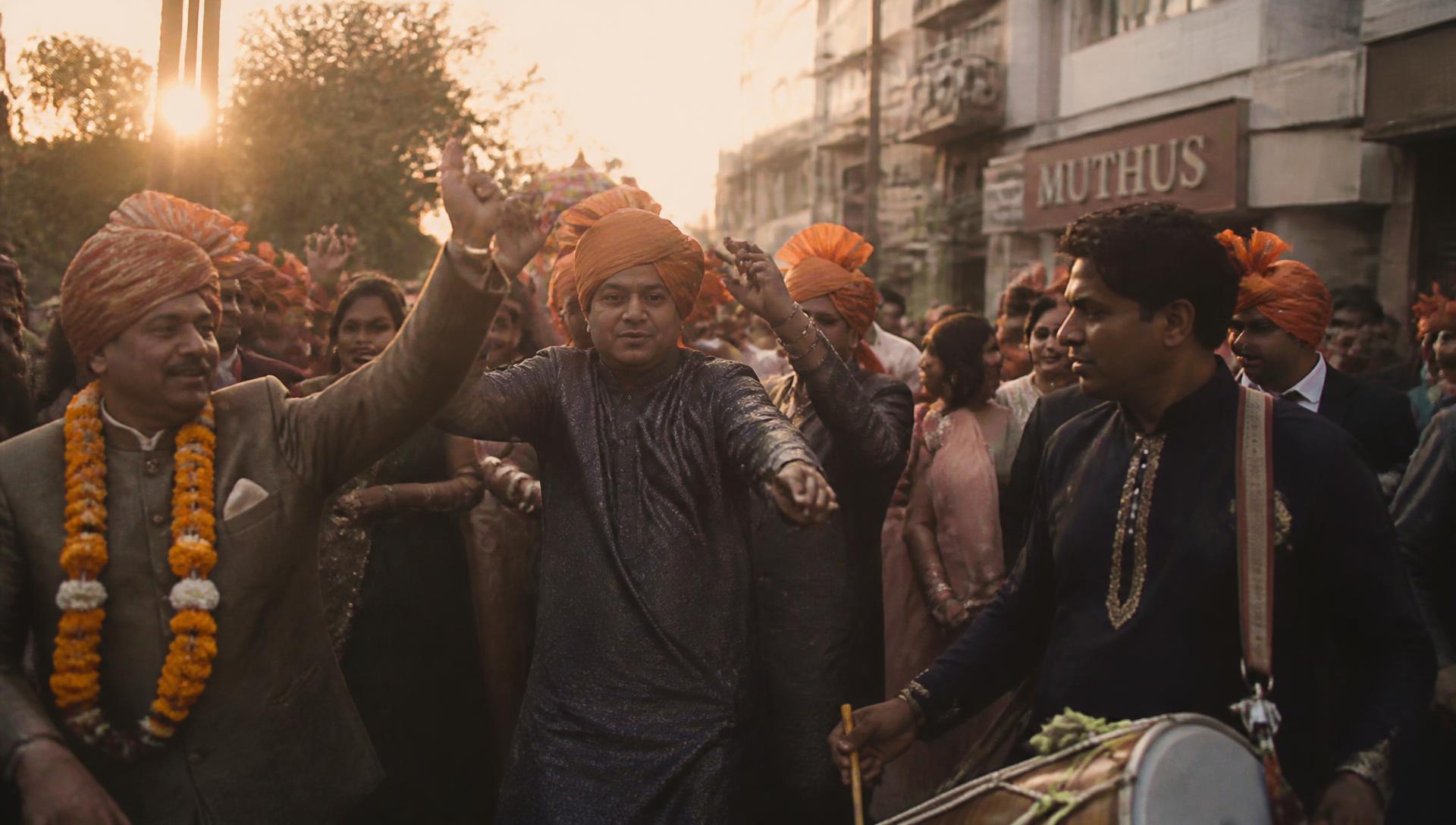 Baraat procession dancing on a street at golden hour